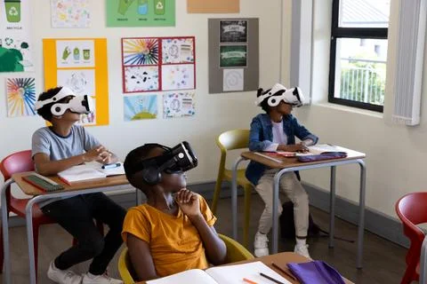 Diverse students in classroom using VR headsets for interactive learning expe Stock Photos