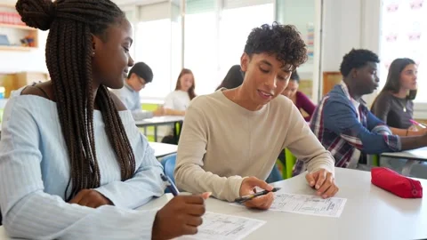 Diverse students collaborating on a classroom assignment Stock Footage 345051767