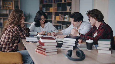 Diverse students studying and collaborating together in a college library Stockbeeldmateriaal 331663443