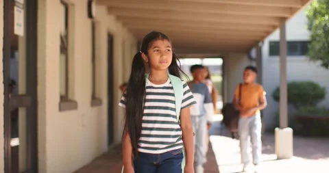 Diverse students walking down shaded school walkway after bell, lead girl Stock Footage 340881612
