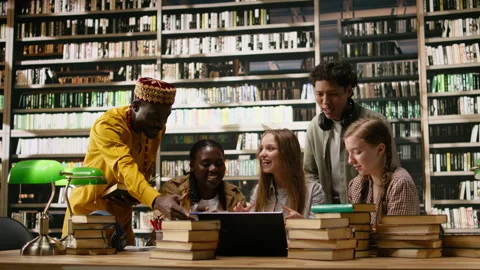 Diverse students working on laptop together at group study session Stock Footage 337229432