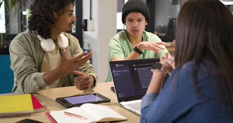 Diverse study group discussing project after chat message appearing on laptop at Stock Footage 341320274