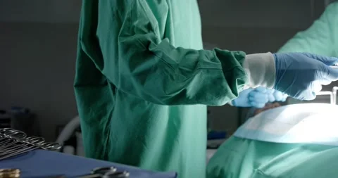 Diverse surgeons with face masks using surgery tools in operating room in slow Stock Footage 344330430