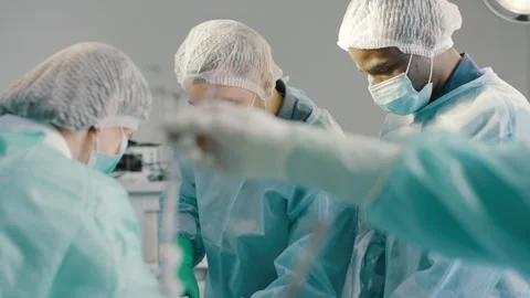 Diverse surgical team performing procedure in operating room Stock Footage 280111655