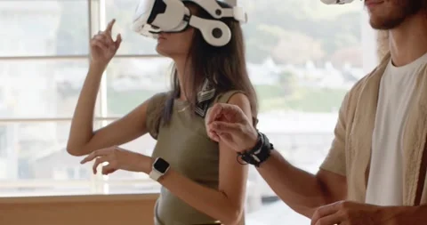 Diverse team after off-screen tablet prompt in studio, woman putting on white VR Stock Footage 339983502
