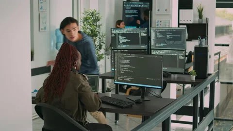 Diverse team of ai cloud programers talking about coding script in front of Stock Footage 217409273