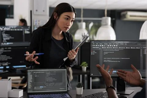 Diverse team of app developers using computer to write html code and develop Stock Photos