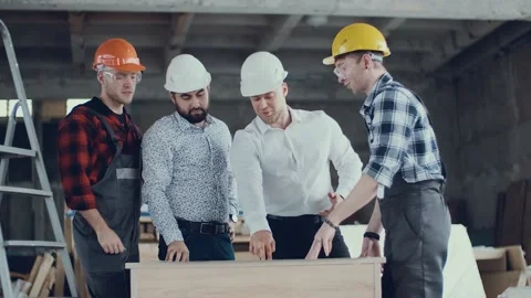 Diverse team of builders is discussing the plan with engineers architects at the Stock Footage 130777215