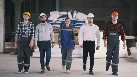 Diverse team of builders with helmets are walking on the construction site Stock Footage 130777214