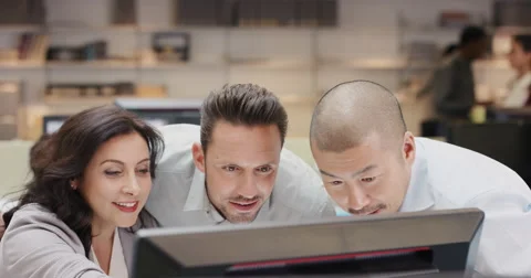 Diverse team of business people working late brainstorming around computer Stock Footage