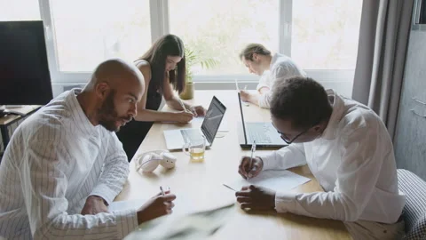 Diverse team collaborates on contract paperwork in a bright office setting Video stock 335746426