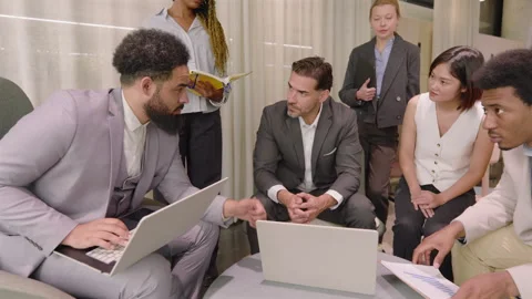 A diverse team is collaboratively analyzing and compiling financial reports and Stock Footage 305431176