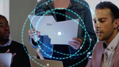 Diverse team at conference table passing sheets while man in pink-blazer typing Vídeo Stock 333317816