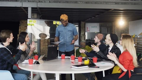 Diverse team of creative developers applauding their Afro-American colleague who Stock Footage 112296428