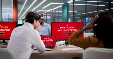 Diverse Team Of Cybersecurity Experts Using Laptops To Stop Ransomware Attack Stock Photos