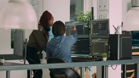 Diverse team of database admins analyzing source code and comparing data script Stock Footage 222023432