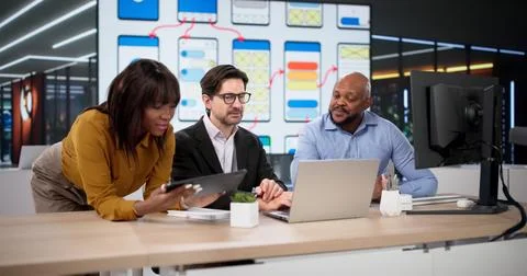 Diverse Team Of Designers And Developers Collaborates On Web Applications Usi Foto stock