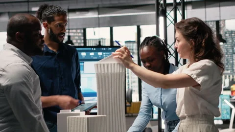Diverse team of developers sharing construction details in a briefing session Stock Footage 316795255