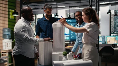 Diverse team of developers sharing construction details in a briefing session Stock Footage 316795377