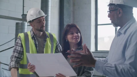Diverse Team Discussing Technical Drawings at Construction Site Stock Footage 332248936