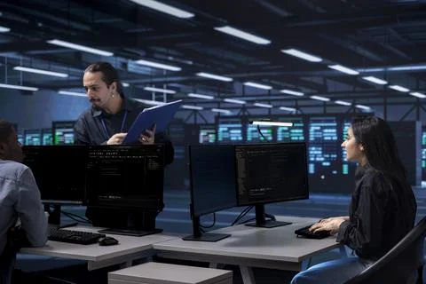 Diverse team of engineers looking for bugs causing infrastructure to slow down Stock Photos