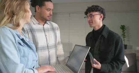 Diverse team entering office placing VR headset and showing devices, reviewing Stock Footage 344333296
