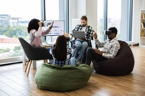 Diverse team exploring virtual reality technology in creative workspace Stock Photos