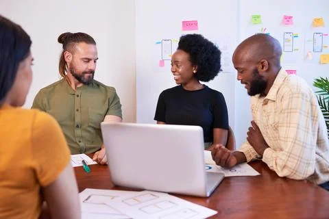 Diverse team of four mobile app developers discuss design during meeting Foto stock