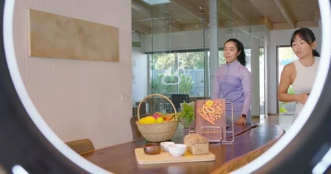 Diverse team high-fiving placing cookbook and basket at table framing DSLR under 스톡 동영상 335212557