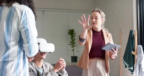 Diverse team introducing VR demo with tablet in office lounge, man mimicking Stock Footage 335454287
