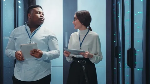 Diverse team of IT specialists opening server cabinet on rack solving problem Stock Footage 119782441