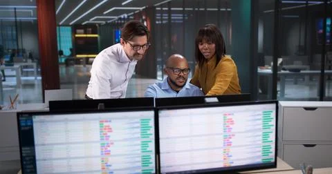 Diverse Team Meets In Office, Analyzing Data On Computers And Spreadsheets. A 库存照片