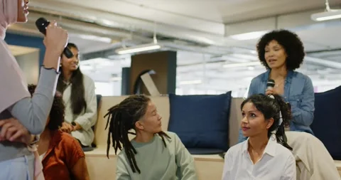 Diverse team at office hearing pink-hijab woman with mic starting meeting peer Видео 345750500