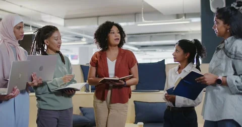 Diverse team in office listening while leader opening notebook and pen, pointing Stock Footage 345818690