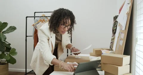 Diverse team opening boxes, checking garments, labeling shipments, hanging Stock Footage 336173919