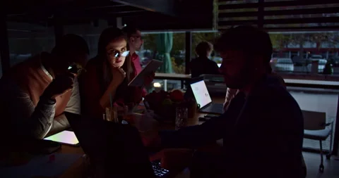 A diverse team of professionals focused on a project during late-night hours in Stock Footage 272234088