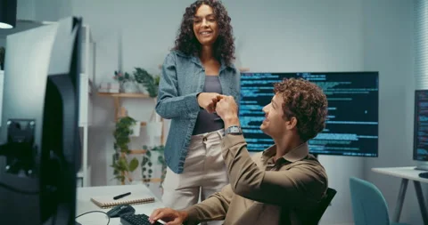 Diverse team programmers give fist bump to celebrate success at office. Stock Footage 344033289