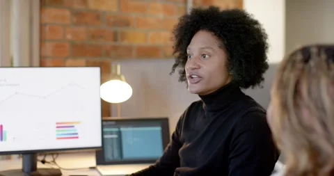 Diverse team reacting to update at desk, African American woman explaining data, Stock Footage 340148072