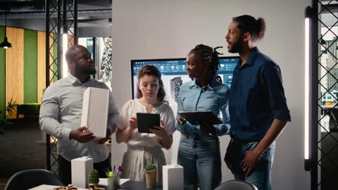 Diverse team of real estate developers using 3D models in a modern office Stock Footage 316649758