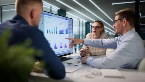 Diverse Team Reviews Risk Data Together While Using Compliance Software. Stock Photos