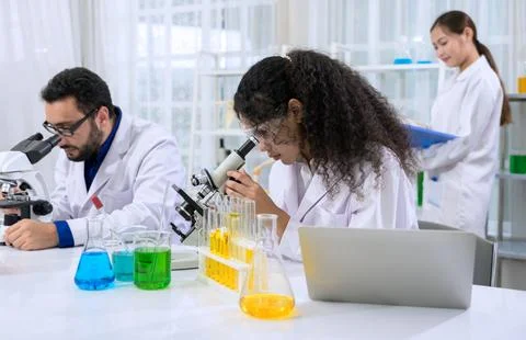 Diverse team of scientists working in research laboratory with microscopes Stock Photos