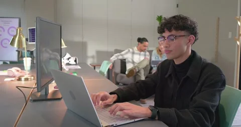 Diverse team seeing chat bubbles on monitor, male typing on laptop pair Stock Footage 337624219