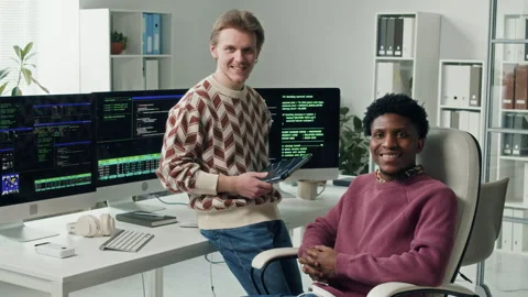 Diverse Team of Smiling Developers Posing at Workstation in Office Stock Footage 330127199