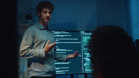 Diverse team software developer present coding to colleague at office night. 動画素材 347148855