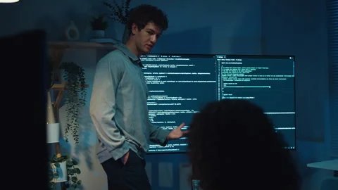 Diverse team software developer present coding to colleague at office night. 動画素材 347149027