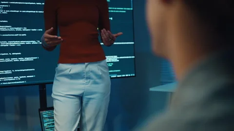 Diverse team software developer present coding to colleague at office night. 動画素材 347149065