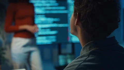 Diverse team software developer present coding to colleague at office night. 動画素材 347149085