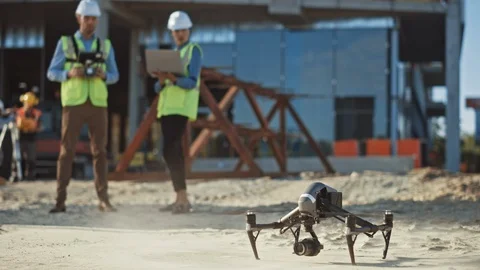 Diverse Team of Specialists Pilot Drone on Construction Site. Stock Footage 113331409