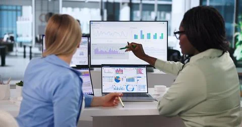 Diverse Team Studies Financial Data On Laptop To Improve Business Decisions. Stock Photos