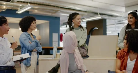 Diverse team on tiers, standing pen-gesturing speaker, pink hijab woman using Stock Footage 345766054